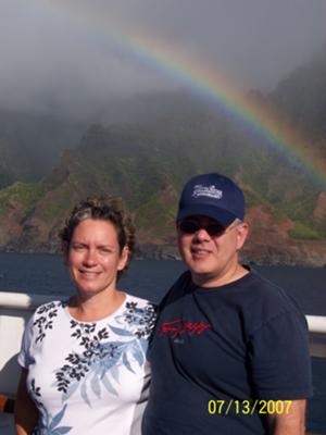 Picture of a couple and the Maui coastline with a rainbow.