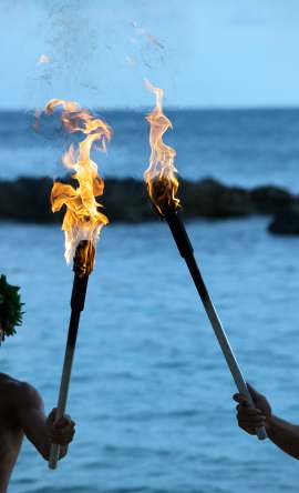 maui luau torches lighting beach at sunset