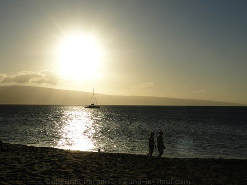 Picture of a couple walking on Kaanapali Beach, Maui at sunset.