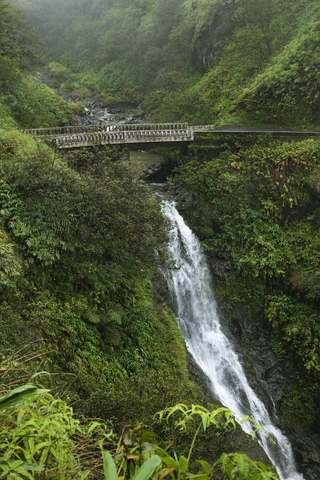 Road to Hana Maui one lane bridge with waterfall Road to Hana Maui one lane bridge with waterfall