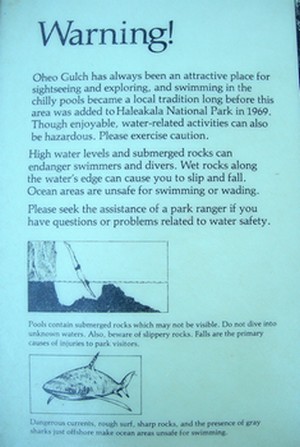 picture of warning sign at Oheo Gulch (Seven Sacred Pools) where stream empties into ocean... warns of sharks and strong currents etc.